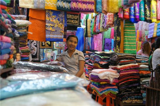 미얀마에서 가장 큰 상설시장인 양곤 보족아웅산 시장에서 한 소녀가 미얀마 전통의상 중 하나인 로지를 판매하고 있다. 