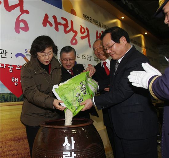 신연희 강남구청장(왼쪽)이 쌀독에 쌀을 붓고 있다.