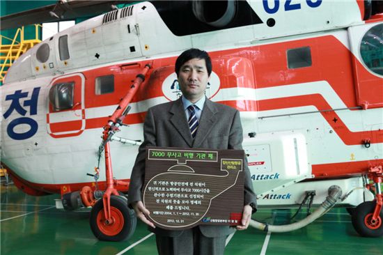 양산산림항공관리소 헬기담당직원이 '무사고비행 7000시간 달성 기념패'를  들고 포즈를 잡고 있다.
