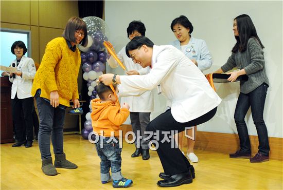 국훈 화순전대병원장이 어린이에게 메달을 걸어주고 있다.