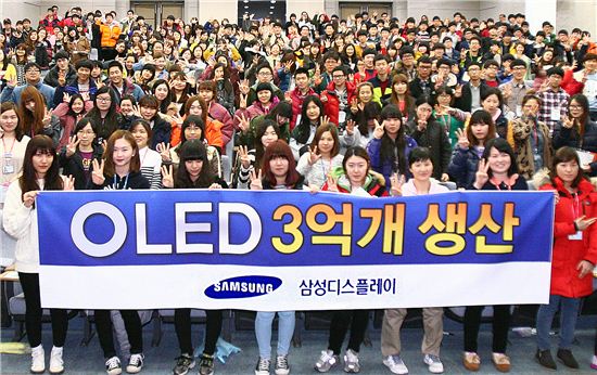 충청남도 아산시 아산캠퍼스에서 OLED 제조센터 직원들이 3억대 돌파를 축하하고 있다.