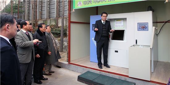 김도연 에코나라 사장(기계 앞에서 서 있는 사람)이 동작구 대방동 한국개나리아파트 단지내 음식물쓰레기 감량화 기기 앞에서 주민들에게 설명하고 있다. 
