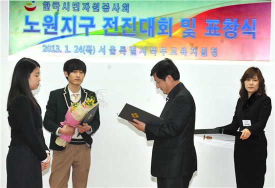 김성환 노원구청장(오른쪽)이 노원지구 샤프론 봉사단 유공 학생들에게 상을 주고 있다.