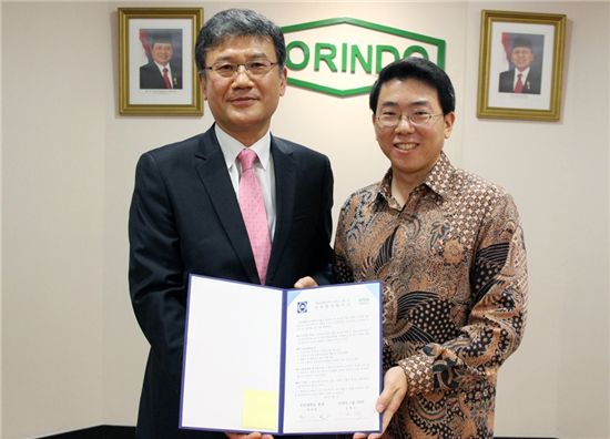 정상철(왼쪽) 충남대 총장과 승범수 코린도(KORINDO)그룹 최고경영자(CEO)가 산학협력협약서를 펼쳐보이고 있다.