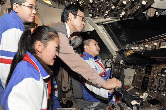 30일 서울 강서구 오쇠동 아시아나항공 본사에서 아시아나항공과 1지점1교 자매결연을 맺은 중국의 '아름다운 교실' 학교 학생들이 기장과 함께 B767 시뮬레이터 체험을 하고 있다.