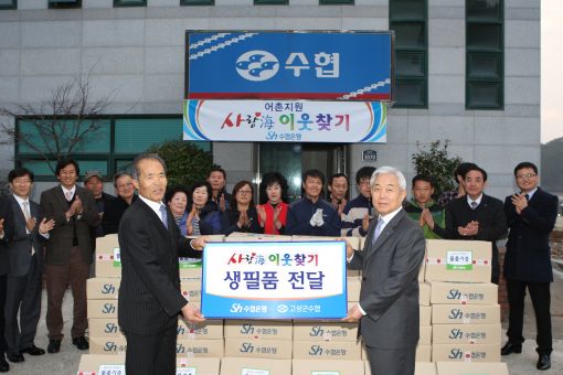 이주형 수협은행장(오른쪽)이 황월식 고성군 수협 조합장에게 생필품을 전달하고 있다.