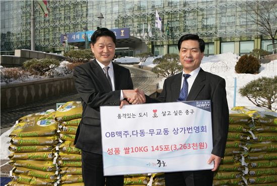 최창식 중구청장(왼쪽)이 박주창 다동.무교동 상가번영회 회장으로부터 쌀 10kg짜리 145포 기증서를 전달받았다.