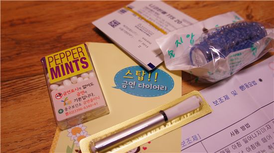 ▲ 보건소 금연클리닉에서 지급되는 금연 보조 제품들. 시계 방향으로 니코틴 패치, 지압기, 주의사항을 적은 종이, 금연 파이프, 은단, 다이어리 등이다.