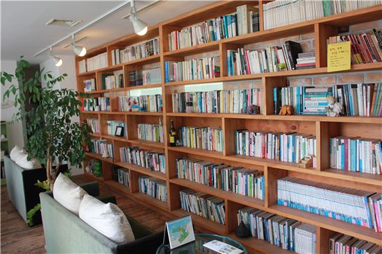 2층 한쪽 벽면에 자리 한 책장. 3000여권의 책이 빼곡히 들어차 있다.