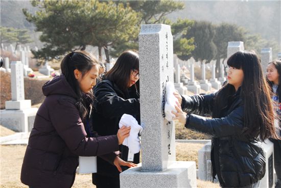 노벨영재교육원 학생들이 묘비를 닦고 있다.