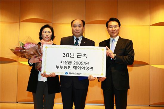 ▲이원희 동아오츠카 사장(오른쪽)이 30년 근속상 수상자인 최재석 서울영업부 과장(가운데)과 부인과 함께 기념 촬영을 하고 있다.
