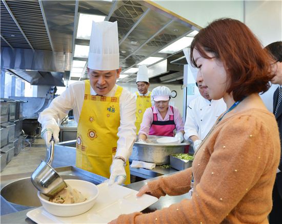 11일 신충식 농협은행장(왼쪽)이 직원식당에서 직접 삼계탕을 배식하고 있다.