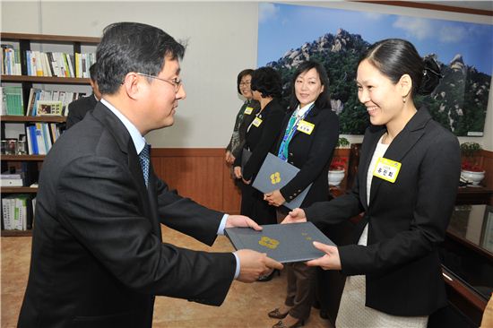 김성환 노원구청장(왼쪽)이 구입여성합창단 신규 단원에게 위촉장을 주었다. 
