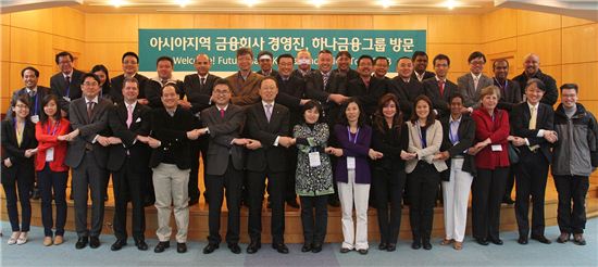 20일 하나금융그룹을 방문한 아시아지역 금융회사 임원단 40여명과 하나금융 관계자들이 손을 맞잡고 기념촬영을 하고 있다. 