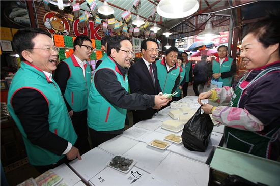김종준 하나은행장(왼쪽 두 번째)이 29일 대전역전 도매시장을 방문해 직접 물건을 구매하면서 활짝 웃고 있다. 