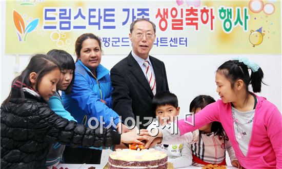 정영오 함평군 주민복지실장과 드림스타트 가족이 생일 축하 케익을  자르고 있다.