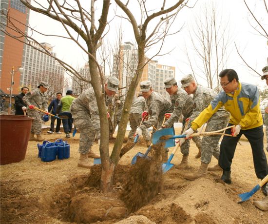 성장현 용산구청장(오른쪽 끝)과 미군들이 나무를 심고 있다.