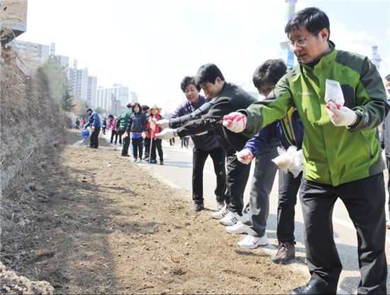 김성환 노원구청장(오른쪽 끝)과 주민들이 당현천변에 꽃씨를 뿌리고 있다.