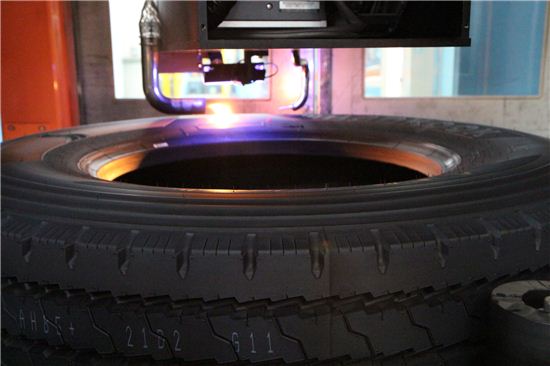 검사 공정 중 X-레이 검사를 마친 타이어에 레이저기계가 바코드를 입력하고 있다.