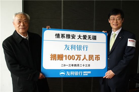 23일 중국 베이징에서 중국우리은행 최만규 법인장(오른쪽)이 중국푸빈기금회 뚜완잉삐 회장에게 쓰촨성 지진 긴급 구호금 100만 위안을 전달하고 있다.