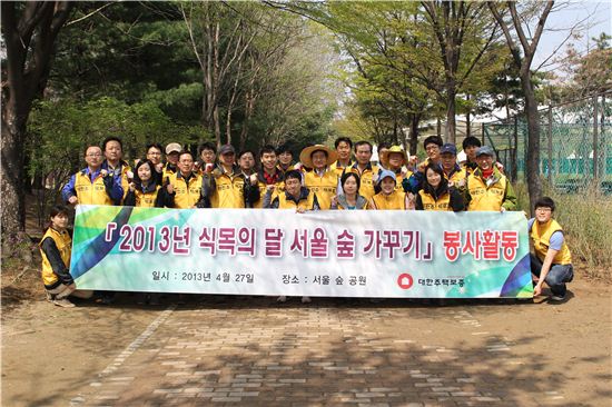 ▲24일 서울 성동구 서울숲에서 식목행사를 가진 대한주택보증 임직원들이 기념 사진을 촬영하고 있다.