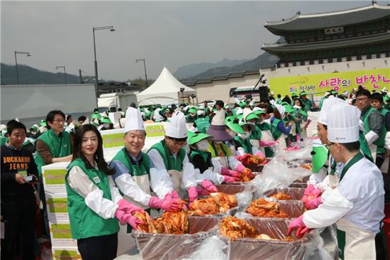 24일 오후 서울 광화문에서 열린 '청정원 사랑의 반찬나눔' 행사에서 명형섭 대상 대표(왼쪽 두번째)와 청정원 모델인 배우 전지현이 절여진 배추에 김치속을 채우고 있다.