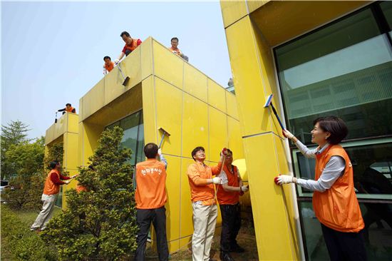 한화그룹 신임 임원들이 7일 서울 은평구 응암동에 위치한 '서울특별시 꿈나무마을'을 찾아 건물 외벽에 페인트칠을 하고 있는 모습.