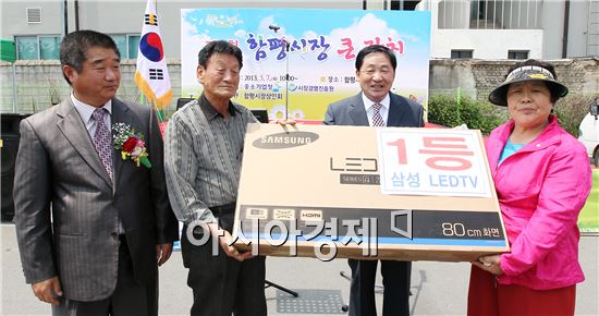 안병호 함평군수(오른쪽에서 두 번째)가 1등 경품을 수상한 군민들과 기념촬영을 하고있다.