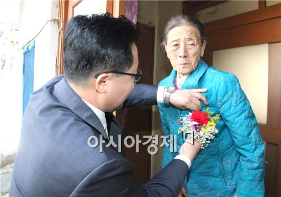 노희용 광주시 동구청장이 독거노인 어르신들에게 사랑이 듬뿍 담긴 카네이션을 달아드리고 있다.