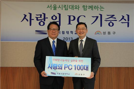 고재득 성동구청장(왼쪽)이 이건 서울시립대 총장으로부터 사랑의 pc 100대를 전달받았다. 