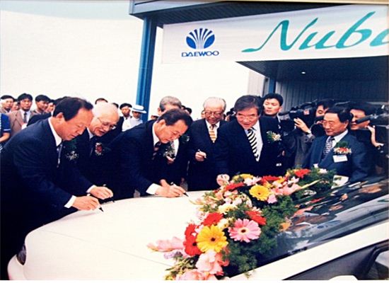 1997년 4월 21일 군산국가산업단지 내 대우자동차 군산공장 준공식에 고건 당시 국무총리(왼쪽 세 번째), 김우중 대우그룹 회장(왼쪽 두 번째)이 참석, 생산 1호차에 기념사인을 하고 있다. 