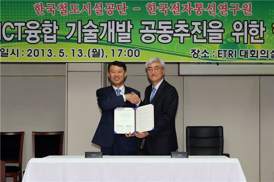 김광재(왼쪽) 한국철도공단 이사장과 김흥남 ETRI 원장이 협약서에 서명한 손을 맞잡고 있다.