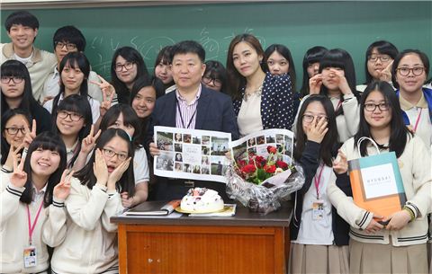 13일 오전 한양대학교사범대학 부속고등학교 3-6반 교실에서 현대백화점 '사랑해요 선생님' 캠페인에  사연을 올린  졸업생 서영롱씨(오른쪽)가 은사 신홍규 선생님께 졸업생들의 사진이 담긴 꽃다발을 선물하고 있는 모습. 

 
