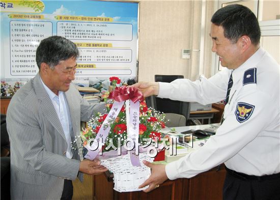 김준일 함평경찰 대동파출소장이 선생님에게 꽃다발을 전달하고 있다. 