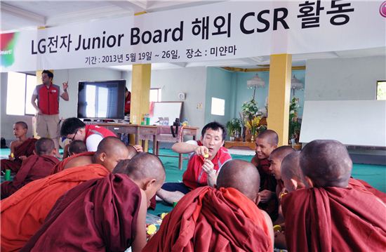 LG전자 사원협의체인 주니어보드 대표들이 미얀마의 한 초등학교에서 아이들과 함께 자가발전 손전등을 만들고 있다. 
