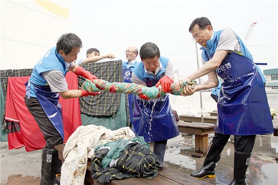 22일 서울 구로구 가리봉동에 위치한 사단법인 지구촌사랑나눔에서 신한은행 임원들이 이불 빨래를 하고 있다. 