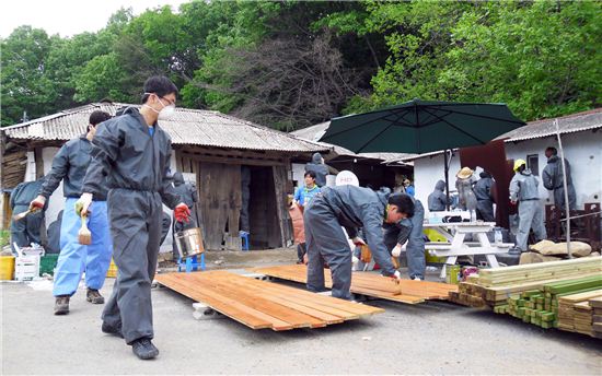 사랑의 집고치기 행사에 참여한 삼성물산 임직원들이 노후된 농가 개보수 작업을 하고 있다. 