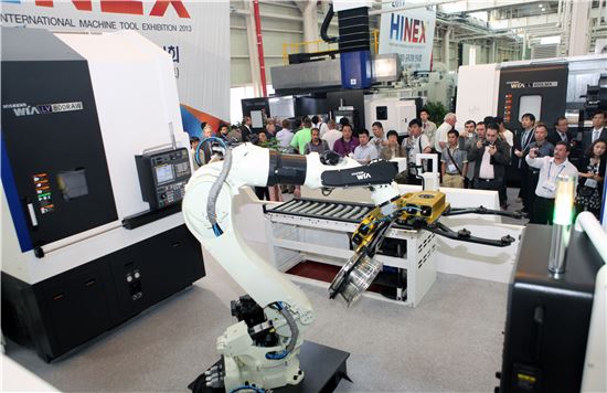 현대위아가 23일 개최한 국제공작기계전시회 2013에서 해외 딜러와 관람객들이 공작기계 및 로봇제품 시연장면을 보고 있다.