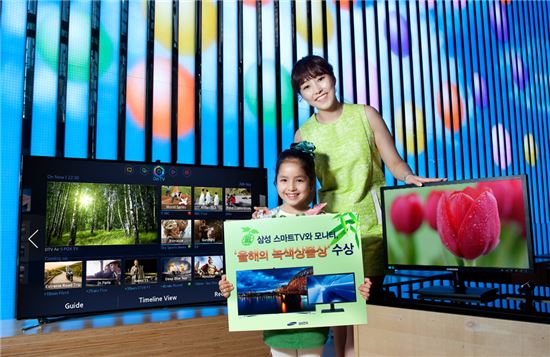 ▲삼성전자 모델이 녹색구매네트워크에서 주관하는 '올해의 녹색상품상'을 수상한 2013년형 삼성 스마트TV 'F8000'과 친환경 모니터 'S23C200B'를 소개하고 있다
