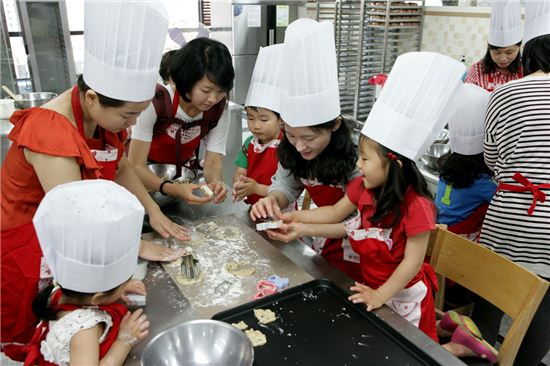 ▲한국거래소 임직원들이 가족과 함께 '사랑빵 나누기' 행사의 쿠키를 만들고 있다.
