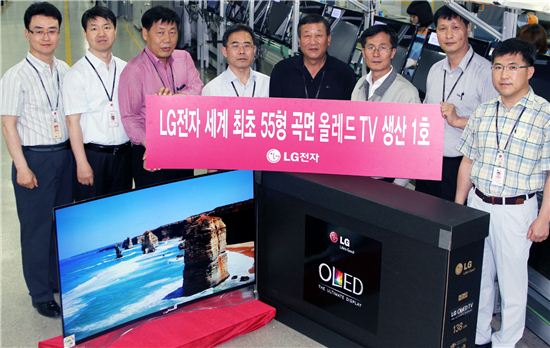 LG전자 직원들이 LG구미공장에서 곡면 올레드 TV 양산 1호 제품과 함께 기념촬영을 하고 있다.  
