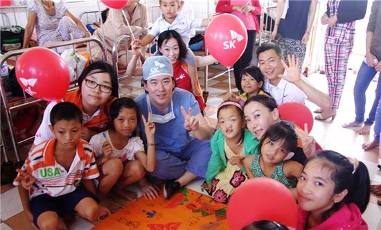 지난 1일부터 8일까지 베트남 중부 빈딩 지역 한 병원에서 진행된 수술에 앞서 베트남 어린이들이 한국 의료진, SK 자원봉사단, SK 대학생 봉사단 써니 등과 수술 성공을 기원하는 승리의 V표를 함께 하고 있는 모습. 