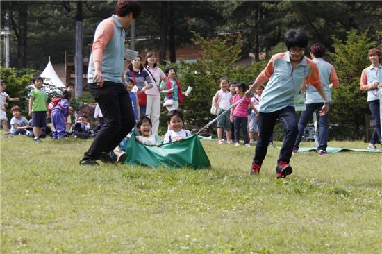 휴양림 잔디밭에서 놀이를 즐기고 있는 어린이들. 