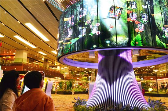 ▲싱가포르 창이공항 이용객들이 LG전자 47형 IPS 디지털 사이니지 64대를 연결한 미디어 조형물 '소셜트리'를 관람하고 있다.   