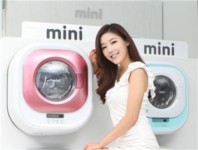 동부대우전자 모델이 25일 출시한 벽걸이세탁기 '미니' 앞에서 포즈를 취하고 있다. 