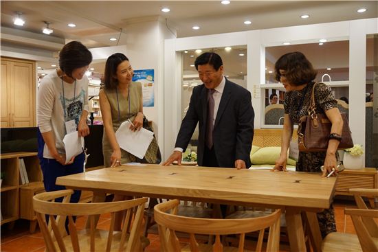 김경수 에몬스가구 회장(오른쪽 두번째)이 고객들에게 제품설명을 하고 있다.