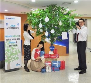 김인규 하이트진로 사장(오른쪽 첫번째)이 서울 서초구 서초동 본사에 설치된 '희망나무'에 달린 엽서를 고르고 있다.