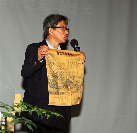 유홍준 명지대 교수가 27일 성동구청에서 '명작의 조건과 장인 정신'이란 주제로 명사특강을 했다. 유 교수가 강의 시작 후 성동구 옥수동 일대에 있었던 독서당계회도를 펼쳐 보이며 독서당의 역사성을 설명하고 있다.