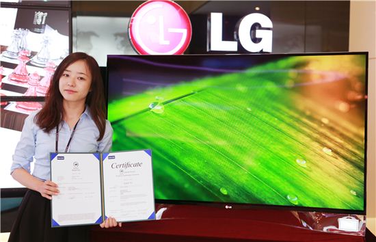 LG전자 TV연구소 연구원이 LG전자 평택 디지털파크에서 인터텍 '그린리프마크' 인증서를 들어보이고 있다. 


