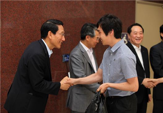 김수관 포스코엔지니어링 사장(왼쪽)이 1일 회사 로비에서 직원들과 악수를 나누고 있다.